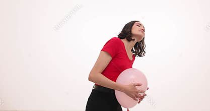 Young woman presses balloon to stomach expressing pain