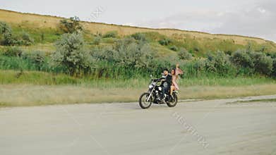 A young couple on a carefree motorbike ride enjoys the freedom of the open landscape together, embracing adventure along