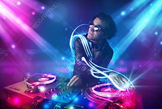Energetic Dj mixing music with powerful light effects