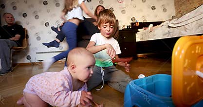 Toddler crawling reaching toy while family plays