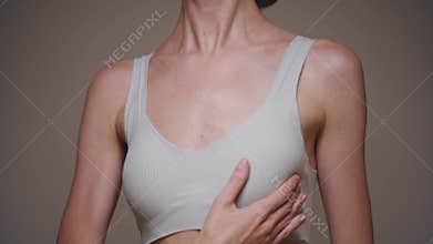 A young woman checks and feels her breasts