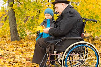 Disabled man and his grandson enjoying autumn