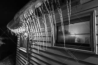 Icicles hanging from an eave at night