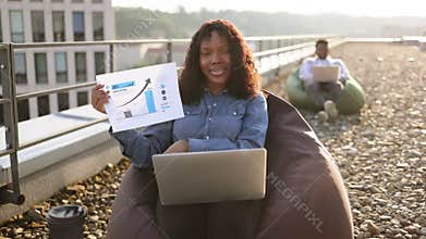 African businesswoman in headset discussing financial plan looking at camera.