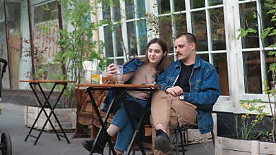 Couple date outside they are talking fooling around laugh funny taking a selfie with a smartphone