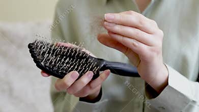 female hands hold a comb and cleanse hair