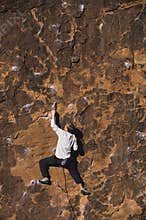 Rock Climber Climbing Up A Cliff