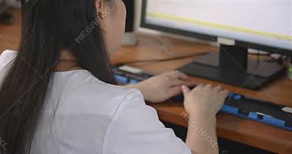 Rear view of woman with blindness disability using computer keyboard and braille display or braille terminal a technology