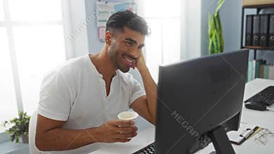 Handsome, hispanic, man smiling in office, holding coffee cup, waving at computer screen during video call, seated at desk with