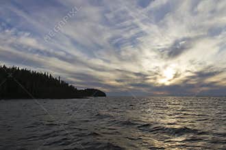 Weak waves, forested coastline and dramatic skies
