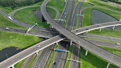 Aerial drone view of a multi-level highway intersection with moving cars near the city of Rotterdam, The Netherlands
