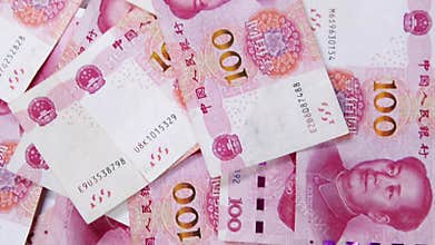 Scattered Chinese 100 Yuan Banknotes Featuring Mao Zedong Portrait and Intricate Currency Design for Financial, Economic