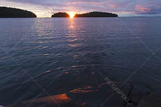Sunset on Lake Ladoga. The sun between two islets