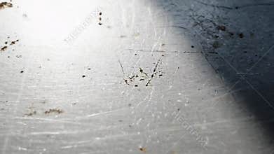 Close-up of a scratched metal surface with shadows and dirt