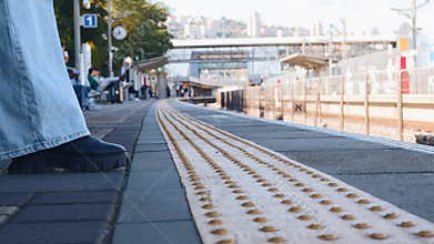 Detectable warning surfaces. Train passengers approach the edge of the platform and wait for the train. Tactile paving