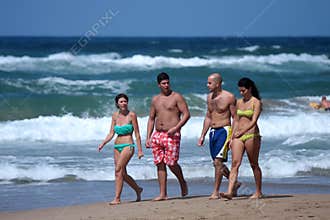 Couples strolling by the sea
