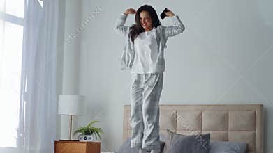 Caucasian woman win phone internet casino betting jumping on bed in bedroom laughing joy female girl with mobile gadget