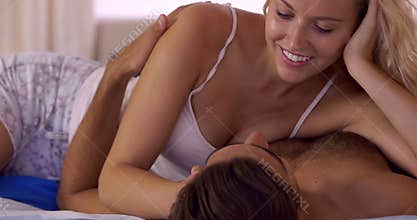 Young couple kissing and cuddling in bed