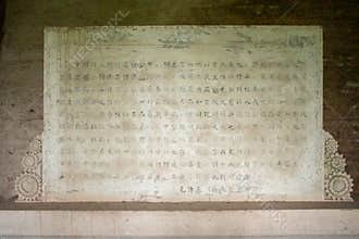 Weathered stone plaque with engraved text and decorative borders