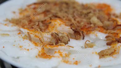 Asian buffet scrambled eggs with dried meat flakes fish topping close-up vibrant breakfast casual dining plated egg dish