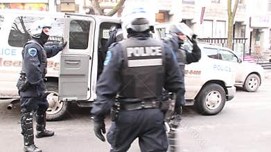 Riot police officers in full gear exit police van