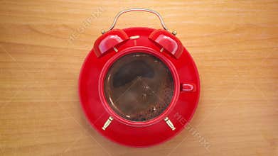 Red coffee cup with alarm clock. Coffee time and wake up concept.
