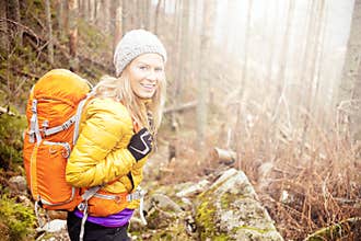 Woman hiking in autumn forest trail