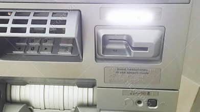 A close-up view of an automated teller machine focusing on card insertion and audio features
