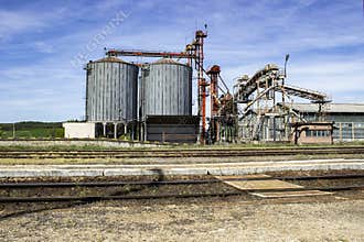 Industrial Grain Silos and Railway Tracks under Blue Sky