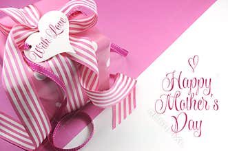 Beautiful pink gift on pink and white background with sample text and copy space for your text here for Mothers Day