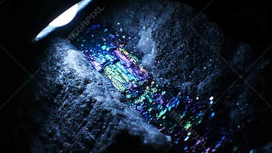 Close-up of Iridescent Bornite Mineral Rock Under Bright Light in Studio