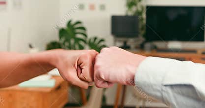 Two Hands Exchange a Friendly Fist Bump Symbolizing Teamwork and Collaboration in a Modern Office
