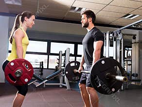 Barbell man and woman workout at fitness gym