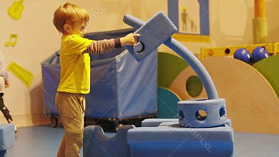 Curious little boy building with large blocks