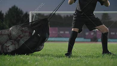 Rome, 9 June 2025: A football boy drags a bag of balls to the stadium at night