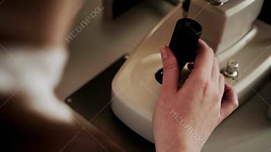 The hand of an ophthalmologist controls the joystick of an ophthalmological device Autorefractometer. Checking the patient's