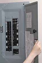 Woman checking automatic fuses at electrical control panel