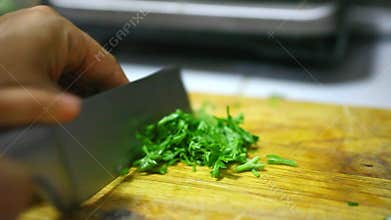 Chopping parsley on a wooden board. Video macro