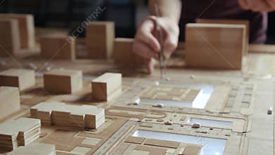 Hands of Professional Man Constructing Architecture Model of Urban City Building