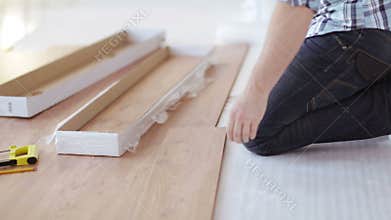 Close up of male hands measuring wood flooring