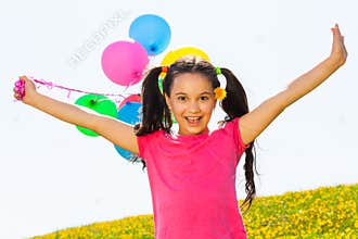 Positive girl with arms up and balloons in air