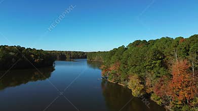 Aerial flyover shot of Lake Johnson park in Raleigh North Carolina with beautiful fall foliage