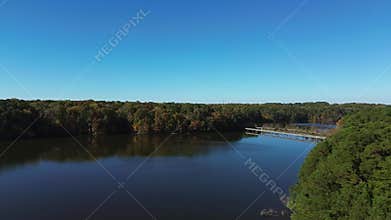 Aerial flyover shot of Lake Johnson park in Raleigh North Carolina with beautiful fall foliage