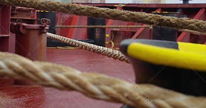 Ropes along with heavy anchor chain lie across wet deck