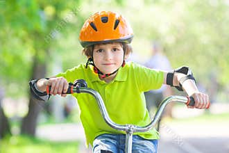 The boy in a safety helmet rides a bicycle