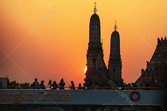 Bangkok, Thailand-January 4, 2025: Wat Arun (Temple of Dawn) with the silhouette of a tourist on a cruise boat