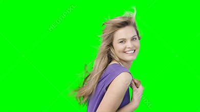 A woman with her hair blowing blowing kisses and flirting