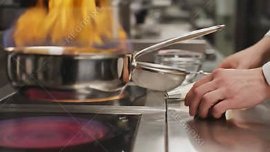 Chef Decorating Golden Muffin with White Cream Frosting Using Piping Bag in Modern Kitchen with Silver Pot on Fire on Stove Top