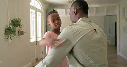 African American dad kneeling, talking at entry arched door, child son hugging, seeking comfort