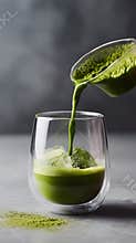 Pouring matcha green tea double wall glass iced beverage powder spill closeup minimal background